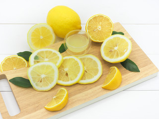 Fresh lemon slice with lemonade on white wood background