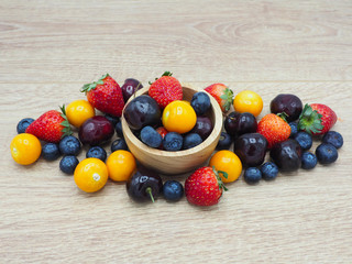 Fresh summer fruits, Cherry, strawberry, cape gooseberry and blueberry in wooden plate isolated on white background.