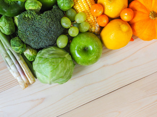 Colorful fresh fruits and vegetables on wood background, healthy eating concept.
