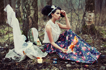 Beautiful lonely girl in the forest burns letters