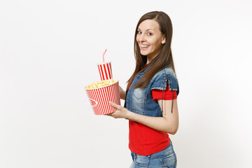 Portrait of young smiling attractive woman in casual clothes watching movie film, holding bucket of popcorn and plastic cup of soda or cola isolated on white background. Emotions in cinema concept.