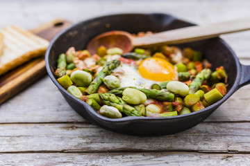 Fried shakshouka with seasonal vegetables asparagus and broad bean.