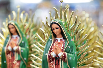 Figurine of the Virgin of Guadalupe sold on nearby stalls - obrazy, fototapety, plakaty