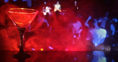 Slider shot. Glass with martini with olive inside. Close up view of glass with club drink on dark foggy toned background. Selective focus. Club drink concept - Powered by Adobe