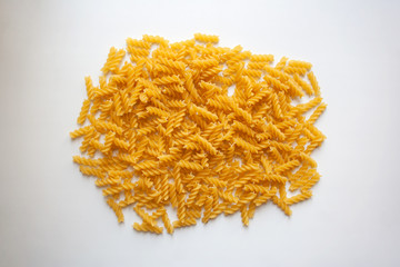 Heap of raw fusilli pasta isolated on white background from a high angle view