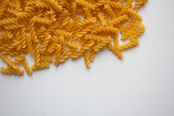 Raw fusilli pasta on white background with free copy space