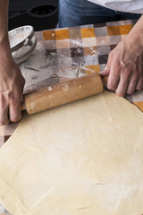 Cooking and home concept - close up of male hands kneading dough on a background in cell