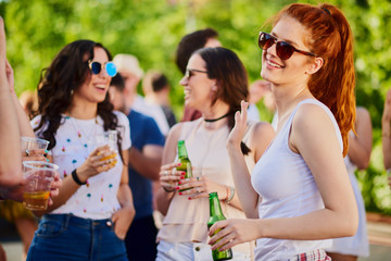 Ginger girl dancing, drinking an having a good time at outdoor party 