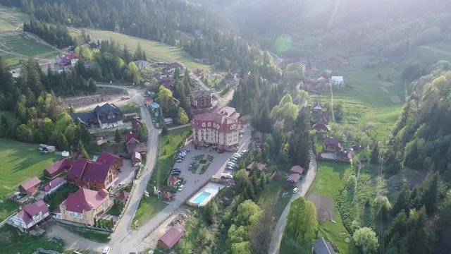 Flying over the beautiful Ukrainian Carpathians mountain and coniferous forest overlooking the beautiful lush green valley and the village. Aerial camera shot. Landscape panorama. Ukraine. Video 4k