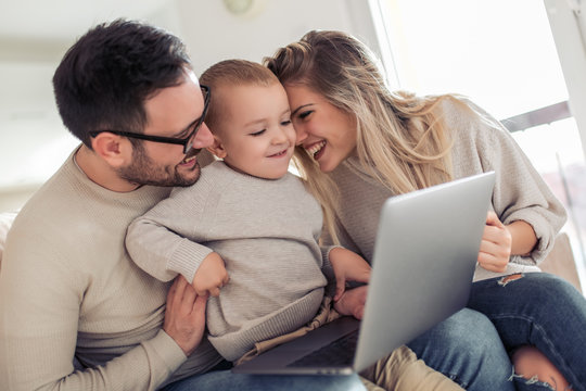 Beautiful young family using laptop