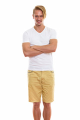 Fototapeta premium Studio shot of happy young handsome man smiling and standing wit