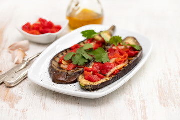 grilled eggplant with red pepper on white dish