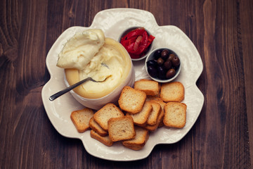 toasts with cheese, olives and red pepper on white dish