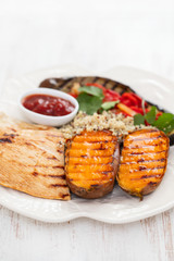 grilled chicken with vegetables and sauce on white dish