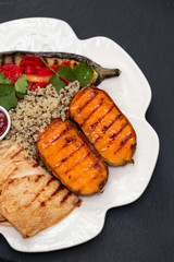 grilled chicken with vegetables and sauce on white dish