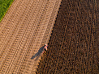Aerial shot of a farmer plowing stubble field © oticki