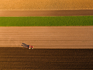 Aerial shot of a farmer plowing stubble field