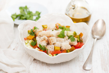 portuguese gaspacho with bread in white bowl on wooden background
