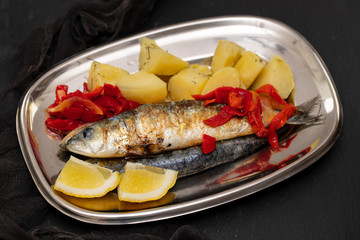 grilled sardines with pepper and boiled potato on dish