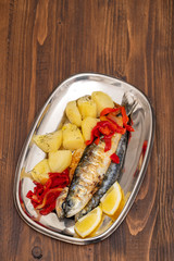 grilled sardines with pepper and boiled potato on dish