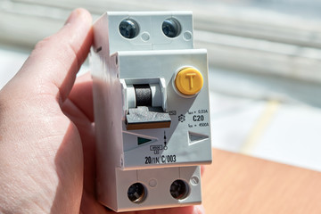 Man holding an automatic switch of differential current. The device protects human life from electric shock. It combines an automatic switch plus a protective shutdown device.