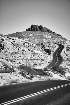 Black and white picture of a scenic desert road, travel concept.