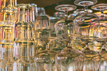 Different glassware and drinkware such as glasses and cognac snifters at a bar or restaurant with beautiful bokeh