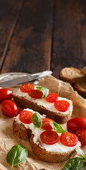 Bruschetta with cream cheese, cherry tomatoes and basil