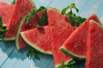 Slices of watermelon on blue wooden desk.