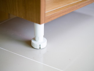 Fototapeta premium Close up adjustable plastic cabinet Leg kitchen leveler