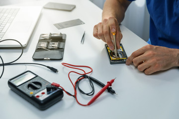 smartphone repairs - technician repairing defective phone