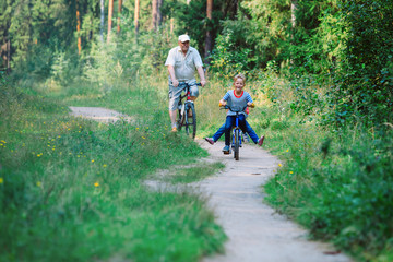 Obraz premium active senior with grandkids riding bikes in nature