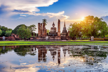 Buddha statue and Wat Mahathat Temple in the precinct of Sukhothai Historical Park, Wat Mahathat Temple is UNESCO World Heritage Site, Thailand.