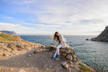 Fototapeta na wymiar Beautiful girl outdoors. Spring day. The girl with long hair photographes itself near the sea