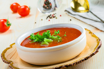 Bowl of gazpacho, bread and vegetables on a table. Tasty Spanish vegan soup. Close-up shot.