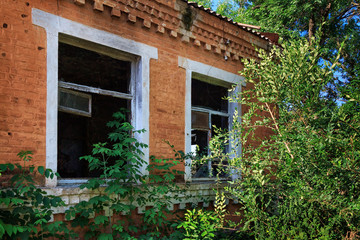 Fototapeta na wymiar Two brocken windows of abandoned house in forest
