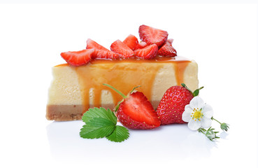 Close-up slice of delicious homemade cheesecake with fresh strawberries, spring flowers and caramel sauce