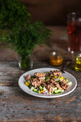 salad with  canned fish, a cucumber, egg and sauce with greens - (meal) - cuisine.  Food background