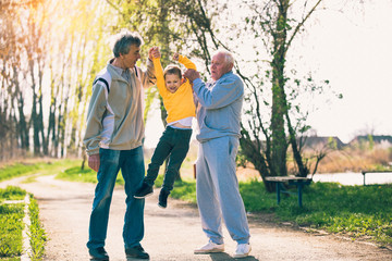 Two grandfather walking with the grandson in the park