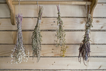 Naklejka premium Dry bundles of medicinal plants hanging on the wall of the boards. Background, blurred