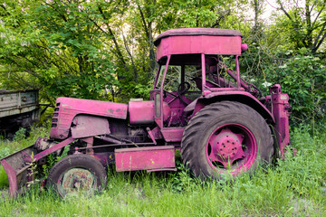 Naklejka premium beautiful, old, pink tractor on the natural background