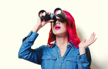 Young pink hair girl in blue shirt holding a binoculars.
