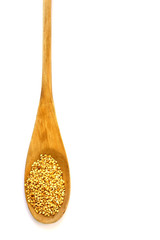 Wooden spoon with a long handle is filled with sesame seeds. Isolated on white. The concept- kitchen, cooking, vegetarianism, healthy food.