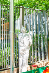 A man paints a fence