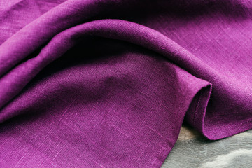 Textile purple napkin on wooden table