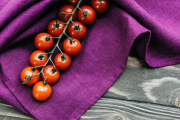Cherry tomatoes branch on purple napkin © LIGHTFIELD STUDIOS