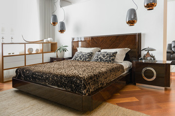interior of modern light bedroom with lamps and brown bedsheets
