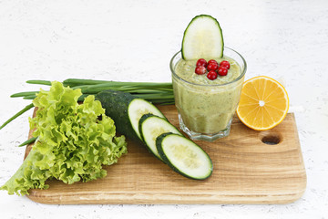 The concept of purification from detoxification, the ingredients of a green vegetable cocktail. Natural, organic healthy juice in a bottle for a diet for weight loss or fasting. 