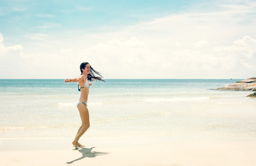 Fototapeta na wymiar Young slim woman dancing on tropical beach