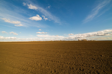 Fototapeta na wymiar Agricultural landscape, arable crop field. Arable land is the land under temporary agricultural crops capable of being ploughed and used to grow crops.